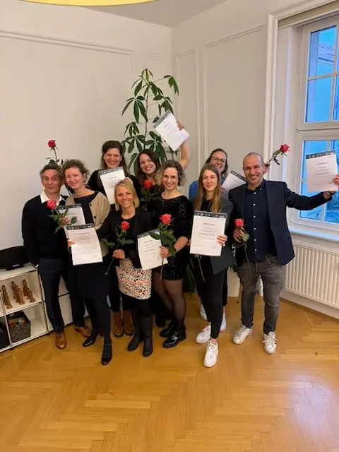 Absolvent:innen mit Zertifikaten und Rosen beim Abschluss der Weiterbildung im ABIS Leipzig