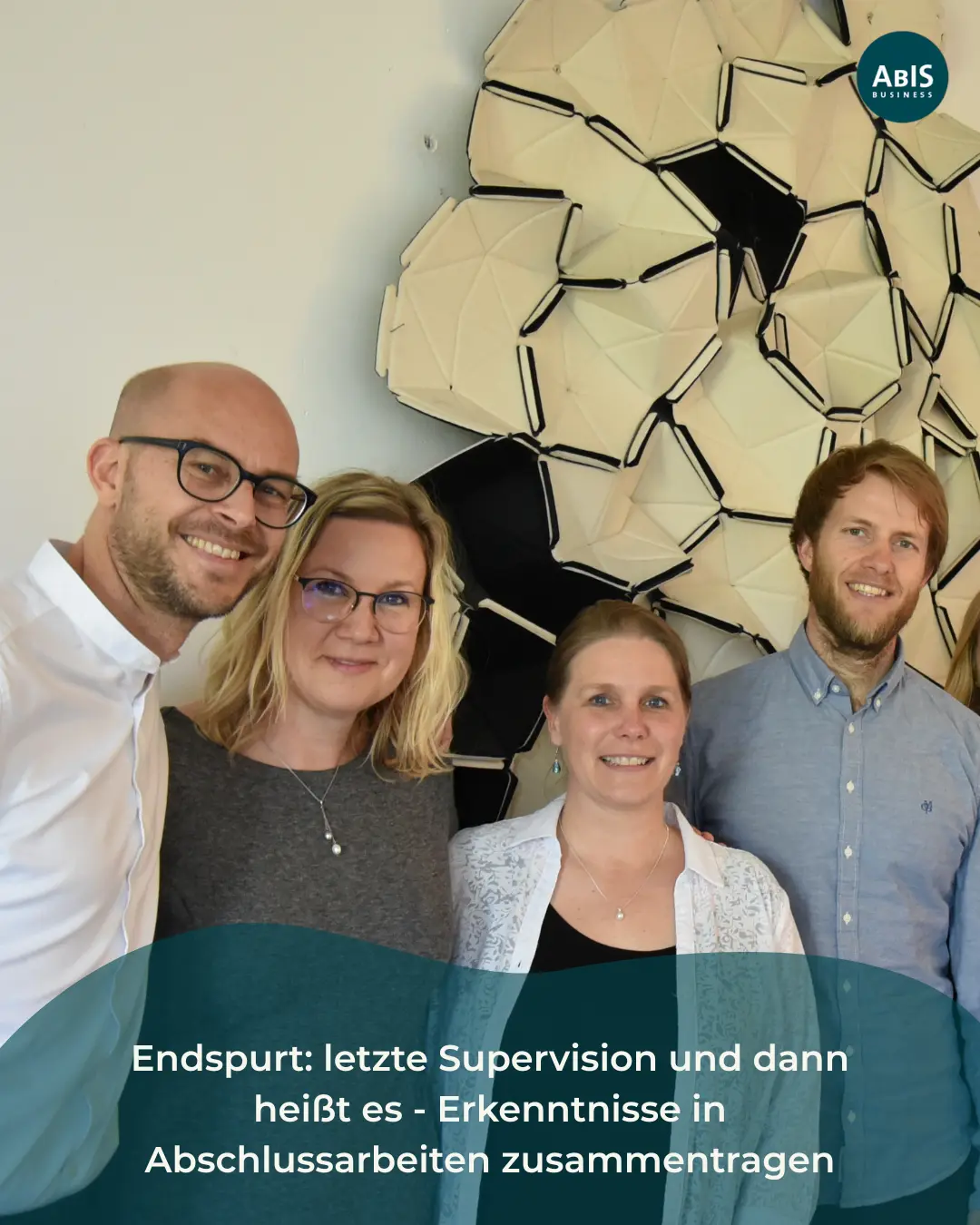 Vier Teilnehmende der Weiterbildung stehen lächelnd zusammen und blicken in die Kamera nach einer Supervisionssitzung.