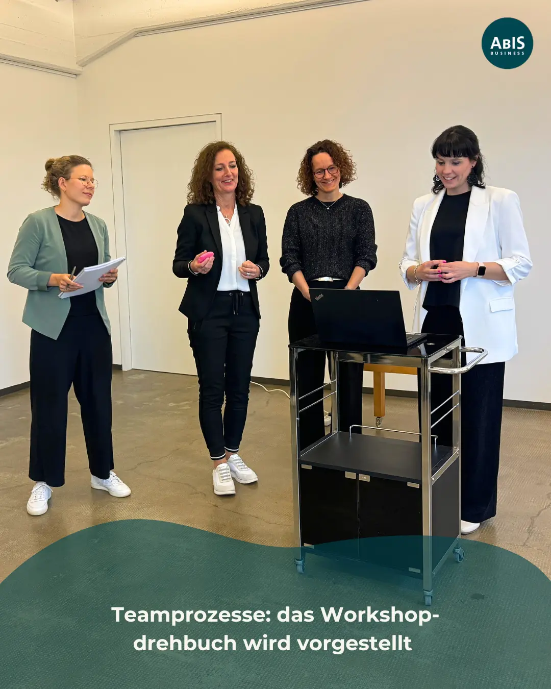 Vier Teilnehmende stehen gemeinsam vor einem Laptop und präsentieren ein Workshop-Drehbuch im Rahmen eines simulierten Trainings zu Team- und Beratungsprozessen.